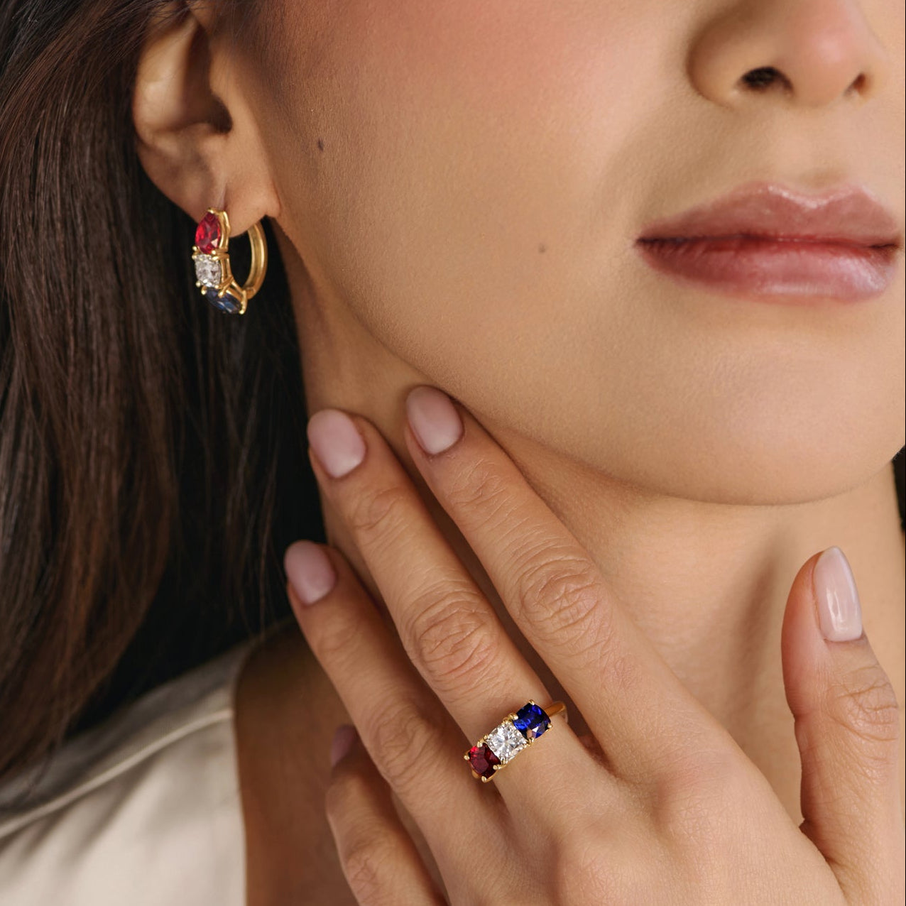 Close-up of cushion-cut lab-grown diamond ring with ruby and sapphire side stones in three-stone setting
