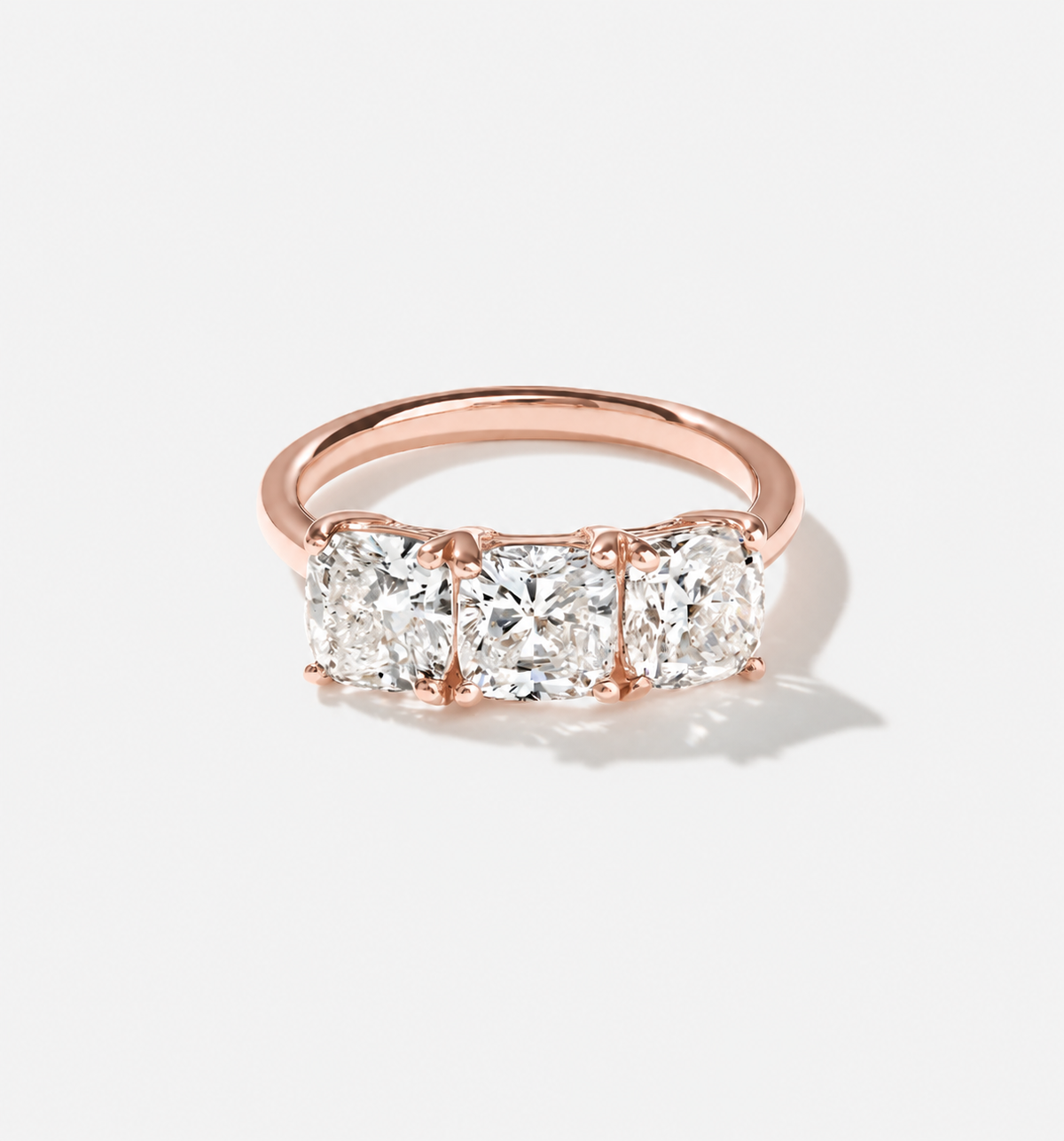 Three-stone cushion-cut lab-grown diamond ring in 14k rose gold.